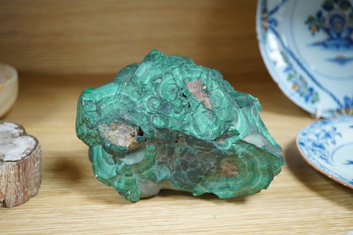 Two petrified wood ashtrays, a malachite rock, three onyx bowls, one with cover, and one other item, larger ashtray 17.5cm wide